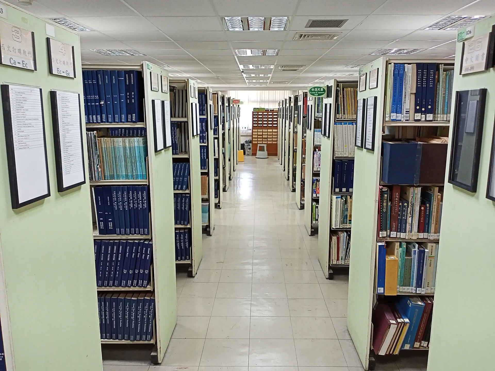 ערימת ספרים וקובץ סיפורים קצרים פתוח על שולחן עץ